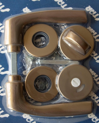 Quincaillerie de porte MONET sur rosace, WC, anodisation bronze