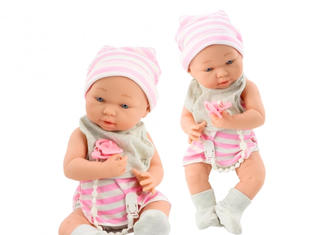 Stoffbaby in Weiß-Rosa Kleidung mit Mütze und Schnuller