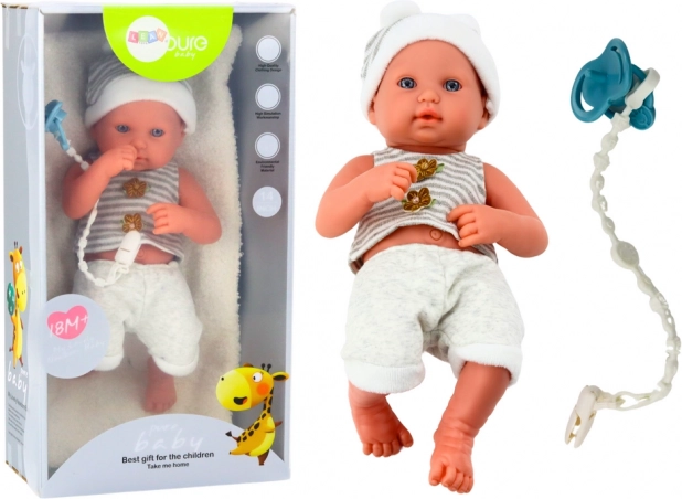 Realistic baby doll in a white–gray outfit with pacifier loop and blanket
