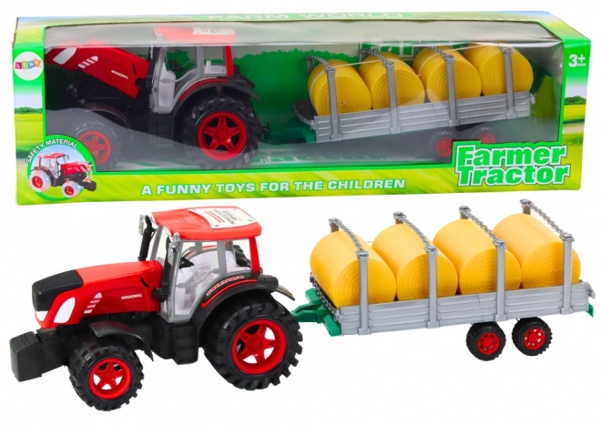 Grote tractor met aanhanger en pakken hooi