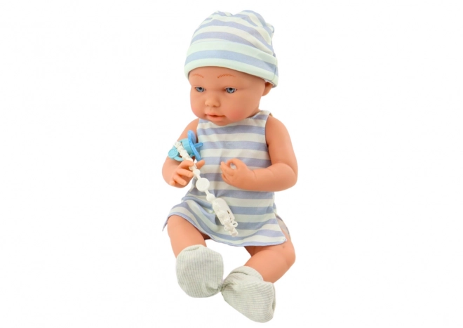 Puppe Baby in Weiß-blauem Outfit mit Mütze und Schnuller