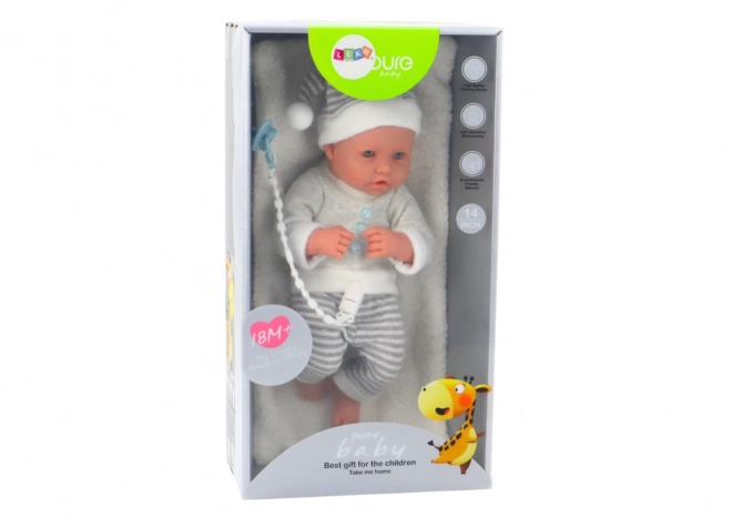 Levensechte babypop in wit-grijze outfit met muts en fopspeen