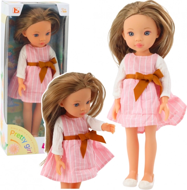 Doll Pretty Girl in a Pink Dress with a Bow and Long Brown Hair