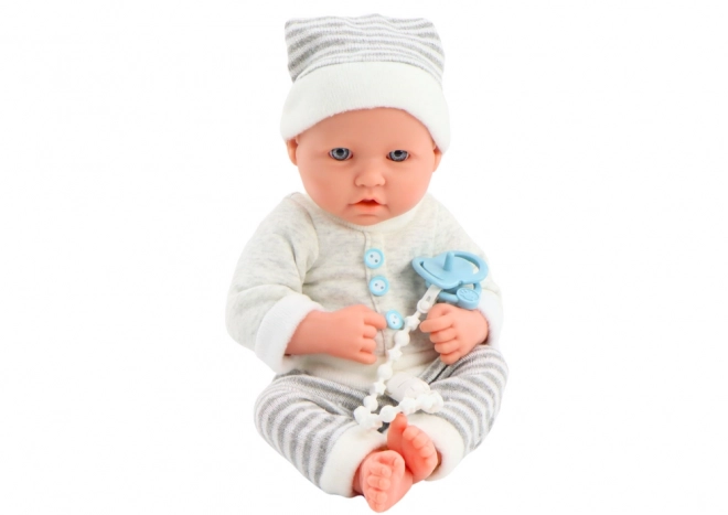 Levensechte babypop in wit-grijze outfit met muts en fopspeen