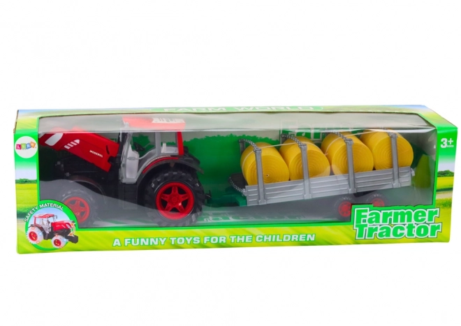 Grote tractor met aanhanger en pakken hooi