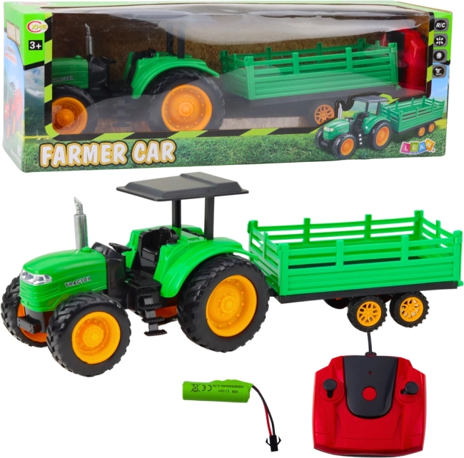 Groene op afstand bestuurbare boerderijtractor met aanhanger