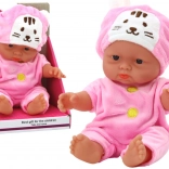 Small baby doll in a pink outfit with a bunny-eared cap